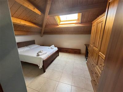 Camera da letto con armadio in legno e lucernario